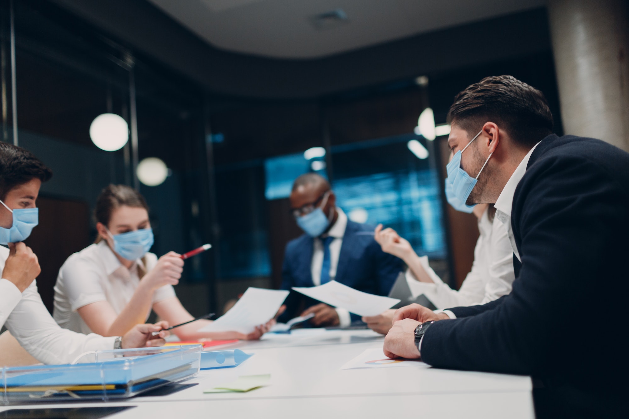 Businessman and businesswoman team in medical face mask at office meeting. Business people group